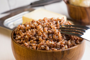 Buckwheat porridge in wooden bowl. Closeup.