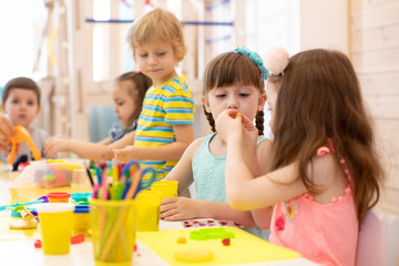 children working with colorful play clay toys