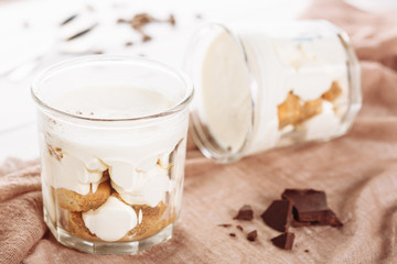 Tiramisu Mousse Chocolate Dessert in Glass Cup. Italian Pudding Cake with Sweet Mascarpone Biscuit. Cocoa Flavored White Cheesecake Confectionery. Traditional Creamy Bakery Cuisine on Brown Table