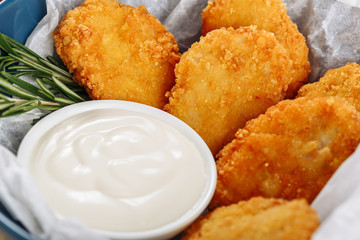 Deep Fried Crispy Chicken Nuggets Close-up Macro View. Tasty Unhealthy Grilled Food on Plate with Mayonnaise Sauce. Dip Fry Meat Breast Strips Appetizer Portion. Golden Roasted Cooked Meal Texture