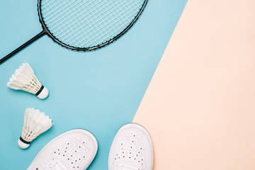 Shuttlecock and badminton racket with sport shoes on pastel color background - obrazy, fototapety, plakaty