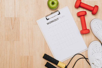 Dumbbells, bottle of water and skipping rope on blue background. Top view. Fitness, sport and healthy lifestyle concept.