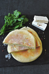 A flat cake stuffed with white cheese and parsley. Middle Eastern cuisine. Healthy food.