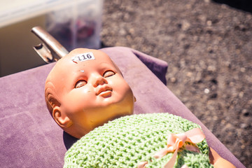 Old scary doll with the number 116 on the head in flea market