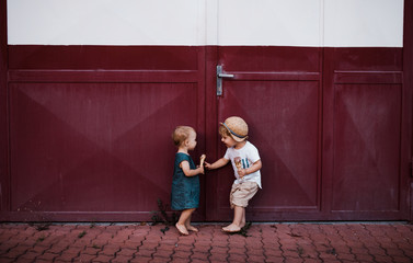 Small two toddler children outdoors in summer, eating ice cream.