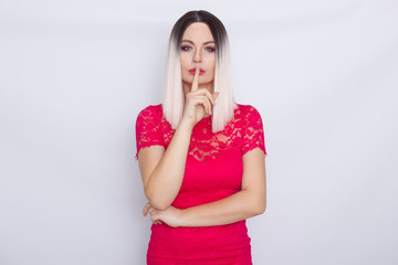 Young blonde woman over white background in bright pink dress