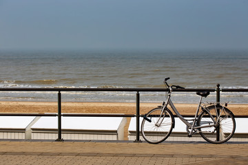 Parked bicycle on a fence near the sea in Middelkerke