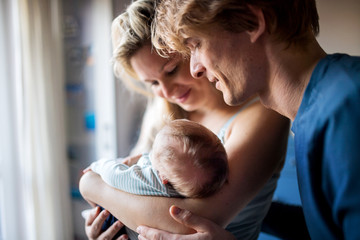 Beautiful young parents with a newborn baby at home.