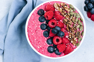 Acai bowl of smoothies with raspberries, blueberries, walnuts, pumpkin seeds and sesame