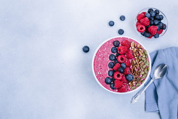 Acai bowl of smoothies with raspberries, blueberries, walnuts, pumpkin seeds and sesame