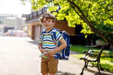 little kid boy with school satchel on first day to school