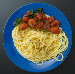 Pasta with tomatoes on blue plate