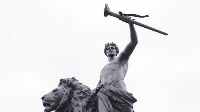 Historic statue of lion and male holding torch | SLOW MOTION