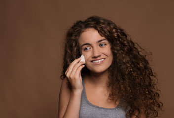 Portrait of a young woman in a studio, brown background. Beauty and skin care.