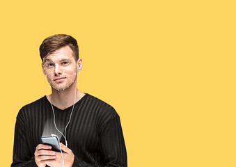 Open for the future. A man with a smartphone in black shirt standing on yellow background. New...