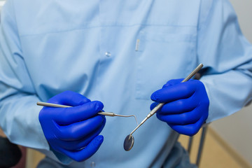 Dentist doctor hands in medical gloves with tools in dental clinic. Orthodontic and dental equipment, health care concept