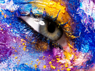 Beauty, cosmetics and makeup. Magic eyes look with bright creative make-up. Macro shot of beautiful woman's face with perfect art make up. Closeup of female eye. Body art