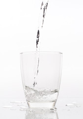 pouring water into glass isolated on white