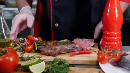 A chef working in the kitchen. A man serving fried steak