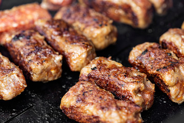 Grilled meat rolls called Mici or Mititei, traditional Romanian food cooked on the grill outside