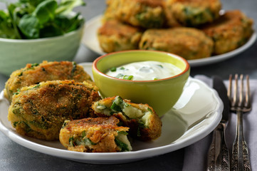 Homemade potato and spinach croquettes with yogurt dip.