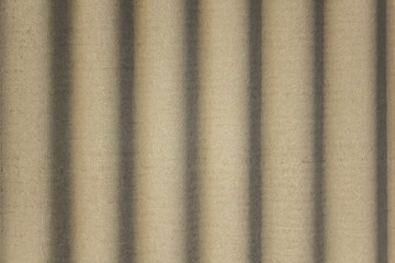 Fototapeta premium gray concrete shield with wavy relief and shadows. vertical lines. rough surface texture