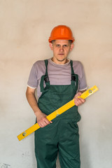 Worker in helmet posing with water level tool