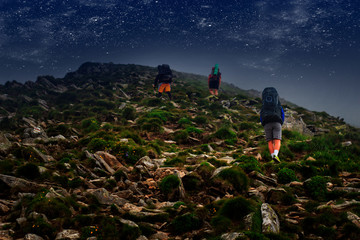 hiking with big backpack in mountains at night