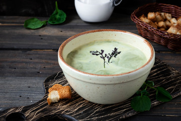 Creamy soup puree with spinach on a dark background