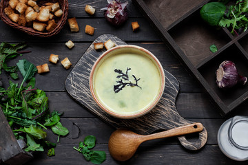 Creamy soup puree with spinach on a dark background