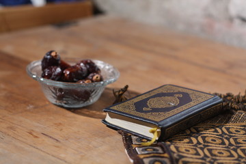 Islamic scriptures and dates on glasses with wooden background - ramadhan concept