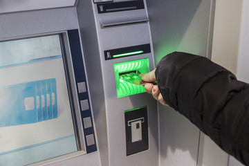 Hand of a woman with a credit card, using an ATM. Woman using an atm machine with his credit card