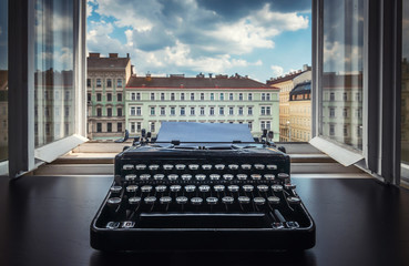 Workplace of a writer, journalist, creator. Old typewriter on the table against the background of...