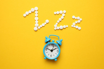 Sleeping pills and an alarm clock, insomnia concept. Stress and sleep problems.