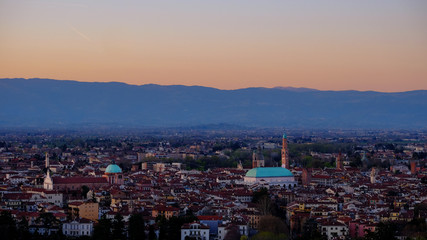 Fototapeta na wymiar wide panorama during the sunset of the city of Vicenza and the famous monument called Basilica Palladiana with the tall Clock Tower. Vicenza, Veneto, Italy - April 2019