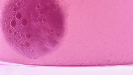 Macro Shot Of An Effervescent Pink Pill Dissolving In Glass Of Water.