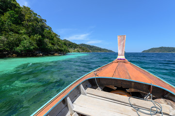 Wooden long-tail boat sailing on tropical sea