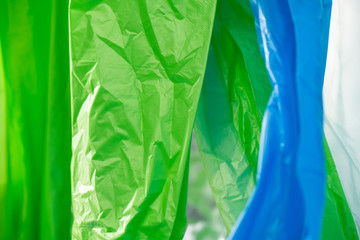 Light green and blue plastic trash bags polluting environment