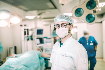 young male surgeon with glasses in the operating room of a medical clinic.