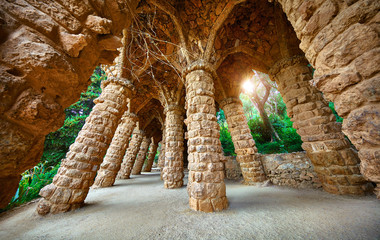 Barcelona, Spain. Park Guell. Antonio Gaudi Art Architecture. Stone pillars with archs at sunset...