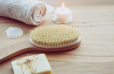 Dry brushing the skin in a pattern with a dry brush, usually before showering help reduce cellulite and remove toxins in human body. Selective focus on firm, natural bristle brush with a long handle. - obrazy, fototapety, plakaty