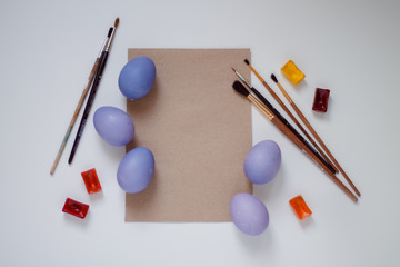 Easter purple eggs with brushes and a sheet for recording