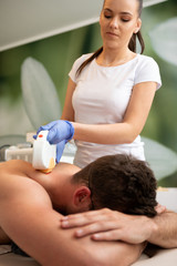 Obraz na płótnie Canvas Cosmetologist removing hair from a man body using laser epilator.