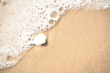 sea wave with bubbles on the sand beach