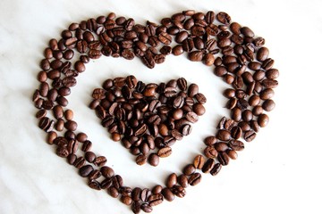 lots of coffee beans, close-up. coffee beans after roasting cool on the table, selective focus. the Heart