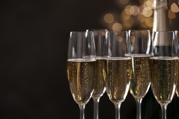 Glasses of champagne on blurred background, closeup. Space for text