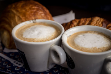 cup of coffee with cream on wooden background
