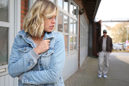 Junge Frau f&uuml;hlt sich von einem Mann verfolgt