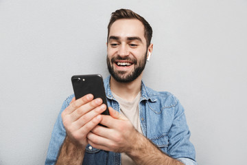 Excited cheerful man wearing shirt standing isolated