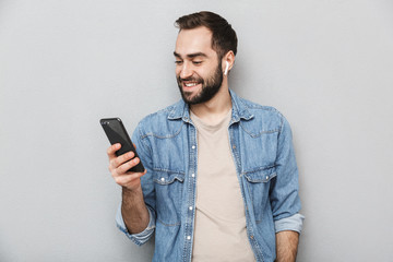 Excited cheerful man wearing shirt standing isolated